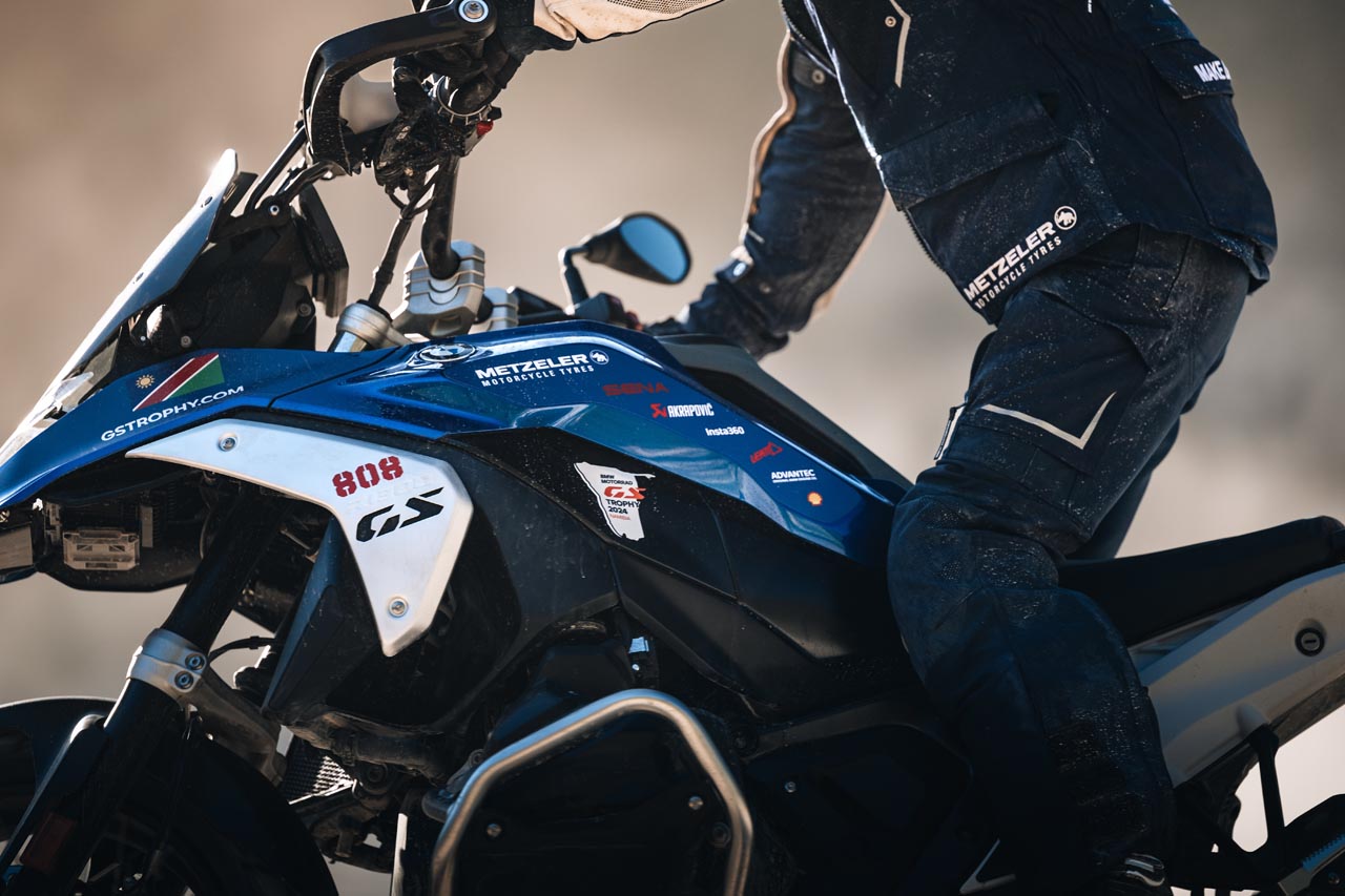 Primer plano de la Moto de Mariscal BMW F 900 GS Trophy, destacando su diseño robusto y sus capacidades off-road, con un pintoresco telón de fondo namibio.