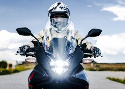 Rider enjoying scenic overlook with Honda Transalp parked nearby