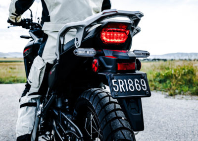 Rider enjoying scenic overlook with Honda Transalp parked nearby