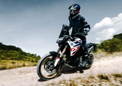 2024 BMW F 900 GS Adventure parked in a rugged terrain, highlighting its off-road capabilities.