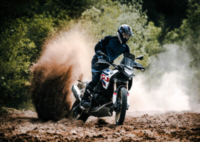 2024 BMW F 900 GS Adventure parked in a rugged terrain, highlighting its off-road capabilities.