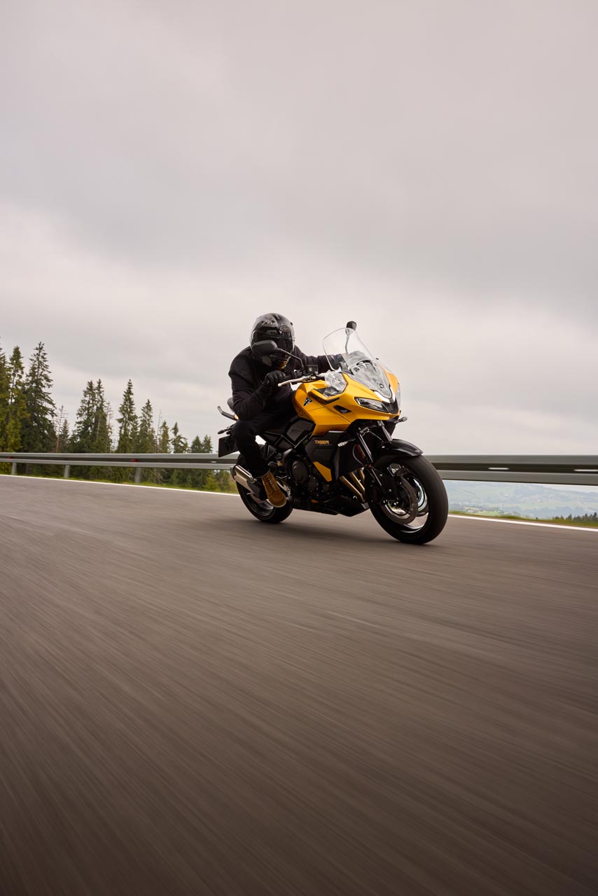 Rider navigating a sharp turn on the Triumph Tiger Sport 800, highlighting its agile handling and Showa suspension.